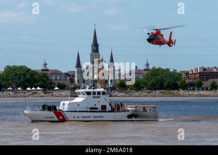 Coast Guard Air Station New Orleans MH-65 Dolphin Helikopter und Coast Guard Cutter Tiger Shark führt Training während der NOLA Navy Week in der Nähe des French Quarter in New Orleans, Louisiana, am 21. April 2022 durch. AIRSTA NOLA, CGC Tigerhai, Hoist, NAVY WEEK, NOLA, Stockfoto