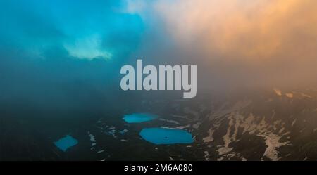 Azgara-Bergseen in den letzten Sonnenstrahlen. Draufsicht durch Wolken. Kaukasusgebirge. Karachay-Tscherkesien. Russland. Stockfoto
