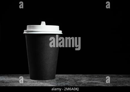 Schwarzer Kaffee oder Tee auf schwarzem Hintergrund mit Kopierbereich, Modell Stockfoto