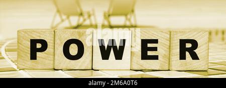 POWER Message Wort auf einem Holzwürfel Blöcke mit einem Ozean Strand Hintergrund. Geschäftsentscheidung, Bildung und Technologiekonzept. Stockfoto