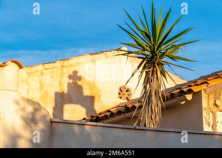 Schatten des kleinen Kirchturms von S'Illot auf einer WallKreu Stockfoto