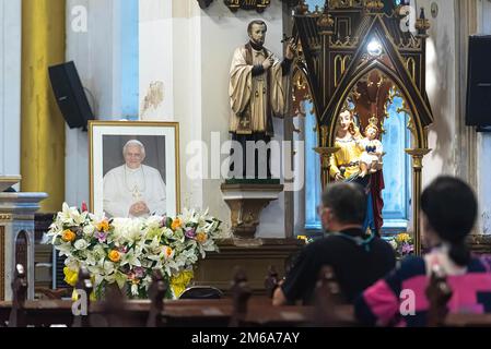 Bangkok, Thailand. 03. Januar 2023. Katholische Anhänger beten vor dem Foto des verstorbenen Papstes in der Rosenkirche während der Hommage an den Tod des Papstes Emeritus Benedikt XVI Der verstorbene Papst Emeritus Benedikt XVI. Starb am 31. Dezember 2022 im Alter von 95 Jahren im Kloster Hook Ecclesiae im Vatikan. (Foto: Peerapon Boonyakiat/SOPA Images/Sipa USA) Guthaben: SIPA USA/Alamy Live News Stockfoto