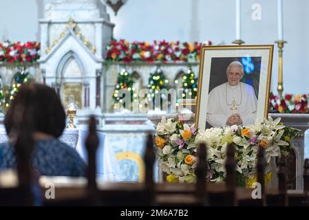 Bangkok, Thailand. 03. Januar 2023. Ein katholischer Anhänger betet vor dem Foto des verstorbenen Papstes in der Heiligen Rosenkirche während der Hommage an den Tod des Papstes Emeritus Benedict XVI Der verstorbene Papst Emeritus Benedikt XVI. Starb am 31. Dezember 2022 im Alter von 95 Jahren im Kloster Hook Ecclesiae im Vatikan. (Foto: Peerapon Boonyakiat/SOPA Images/Sipa USA) Guthaben: SIPA USA/Alamy Live News Stockfoto