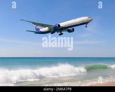 Aeroflot Boeing 777 Flugzeug über Mai Khao Beach Waves nahe Phuket Flughafen, Thailand. Flugzeug der Russian Airlines Boeing 777-300ER über dem Strand. Stockfoto