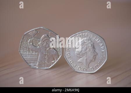 Zwei 50p-Teile mit Königin Elizabeth II. Und Paddington Bär, die eine Flagge schwenken Stockfoto