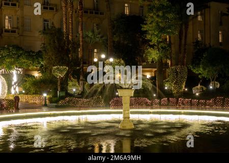 Der mit Flutlicht beleuchtete Garten des Winter Palace Hotel Luxor Egypt während der Weihnachtszeit Stockfoto