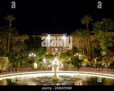 Der mit Flutlicht beleuchtete Garten des Winter Palace Hotel Luxor Egypt während der Weihnachtszeit Stockfoto