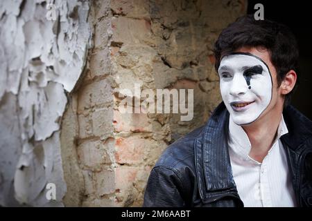 Guy Mime gegen eine alte Mauer. Stockfoto