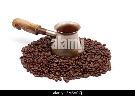 Alte Kupferkaffeekanne mit Kaffeebohnen isoliert auf weiß Stockfoto