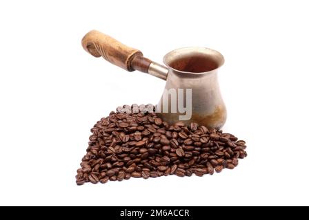 Alte Kupferkaffeekanne mit Kaffeebohnen isoliert auf weiß Stockfoto