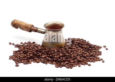 Alte Kupferkaffeekanne mit Kaffeebohnen isoliert auf weiß Stockfoto