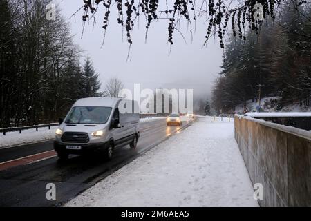 Dunkeld, Schottland, Großbritannien. 3. Januar 2023 Die Temperatur steigt langsam an, und der jüngste Winterschnee beginnt zu schmelzen und verwandelt sich in Matsch. Autos auf der A9 nahe Dunkeld mit niedrigem Nebel und Nieselregen. Kredit: Craig Brown/Alamy Live News Stockfoto