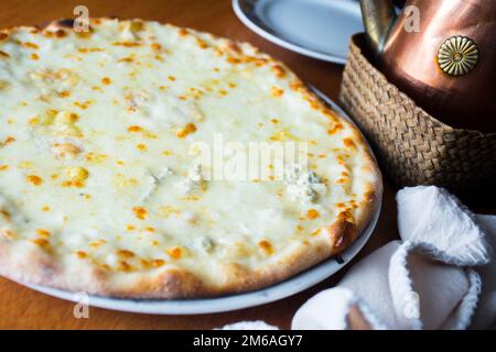 Vier Käsepizzen. Neapolitanische Pizza mit einer Vielzahl europäischer Käsesorten wie Mozzarella, Brie und Gorgonzola. Italienisches vegetarisches Rezept. Stockfoto