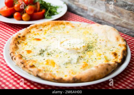 Vier Käsepizzen. Neapolitanische Pizza mit einer Vielzahl europäischer Käsesorten wie Mozzarella, Brie und Gorgonzola. Italienisches vegetarisches Rezept. Stockfoto