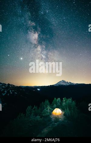 Beleuchtetes Rucksackzelt mit Milky Way über dem Mt. Baker Stockfoto