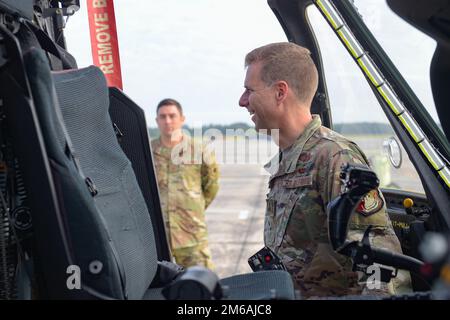 USA Luftwaffenbrücke. General David Mineau, Vizekommandeur der 15. Luftwaffe, reagiert auf einen Airman, der während seines Besuchs am 21. April 2022 auf dem Luftwaffenstützpunkt Moody, Georgia, ein Cockpit des HH-60W Jolly Green II auf der Fluglinie bereist. Die Luftwaffe des 41. Rettungsgeschwaders präsentierten ihre Kampffähigkeiten und erklärten ihre Mission nach Mineau. Mineau besuchte Team Moody, um mehr über die Einsatzkräfte des 23. Flügels und des 93. Luftwaffenflügels zu erfahren. Stockfoto