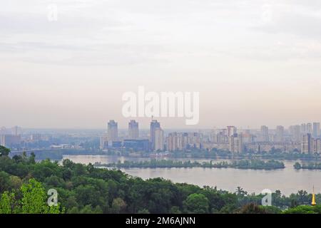 Kiew, Ukraine. Mai 13. 2013. Stadtbild von Kiew, Blick auf das linke Ufer und den Fluss Dnieper. Moderne Stadt in der Ferne, abends. Stockfoto