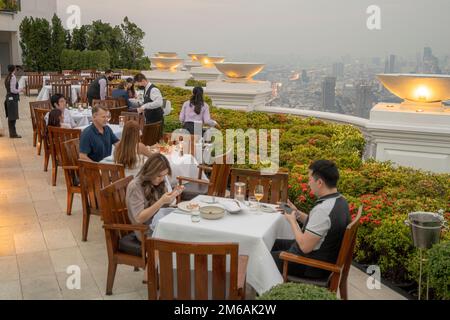 Touristen genießen ein luxuriöses Abendessen in Einer Sky Bar auf dem Dach bei Sonnenuntergang Stockfoto