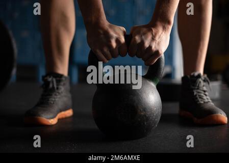 Eine Frau, die sich bereit macht, die Kettle Bell zu heben Stockfoto