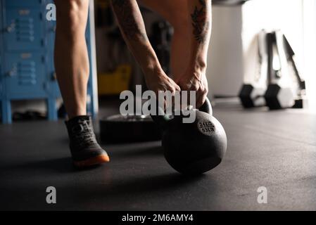 Eine Frau, die sich bereit macht, die Kettle Bell zu heben Stockfoto