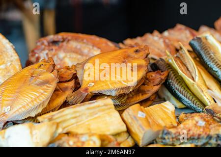 Auswahl an hausgemachtem Räucherfisch auf einem Bauernmarkt in Vilnius, Litauen. Kaziukas, traditionelle Frühjahrsmesse in der Hauptstadt Litauens. Stockfoto