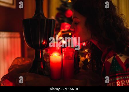 Eine Frau, die zu weihnachten Kerzen ausbläst Stockfoto