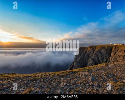 Felsige Schieferküste, Wolkenmeer mit Mitternachtssonne, Besucherplattform am Horizont, Nordkap, Nordkapp, Mageroya, Finnmark, Nordsee, Norwegen Stockfoto