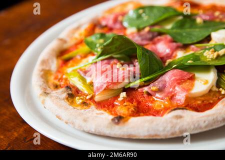 Pizza-Rindfleisch-Carpaccio. Neapolitanische Pizza mit Tomatensauce, Käse und Rindfleisch. Italienisches Rezept. Stockfoto