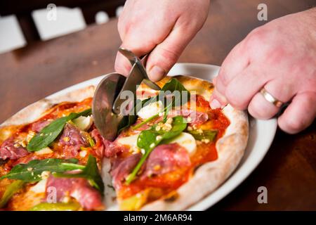 Pizza-Rindfleisch-Carpaccio. Neapolitanische Pizza mit Tomatensauce, Käse und Rindfleisch. Italienisches Rezept. Stockfoto