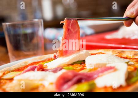 Pizza-Rindfleisch-Carpaccio. Neapolitanische Pizza mit Tomatensauce, Käse und Rindfleisch. Italienisches Rezept. Stockfoto