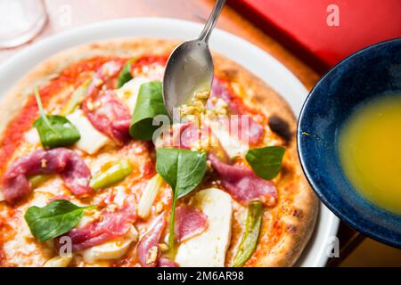 Pizza-Rindfleisch-Carpaccio. Neapolitanische Pizza mit Tomatensauce, Käse und Rindfleisch. Italienisches Rezept. Stockfoto