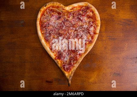 Herzförmige iberische Schinkenpizza. Neapolitanische Pizza mit italienischem Rezept. Stockfoto