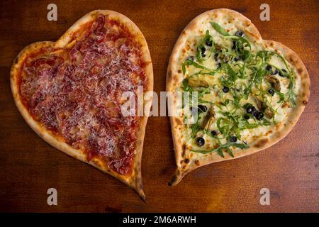 Herzförmige iberische Schinkenpizza. Neapolitanische Pizza mit italienischem Rezept. Stockfoto