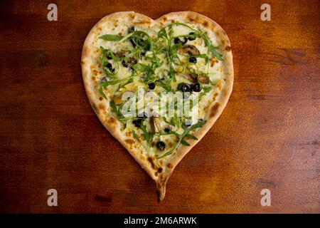 Herzförmige iberische Schinkenpizza. Neapolitanische Pizza mit italienischem Rezept. Stockfoto