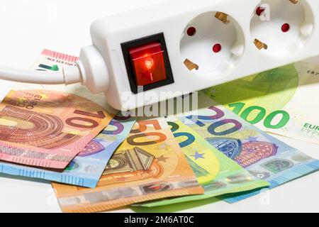 Umschaltbare Steckdosenleiste, Euro-Banknoten, symbolische Kosten für Bildenergie, Stromkosten, Energieeinsparung Stockfoto