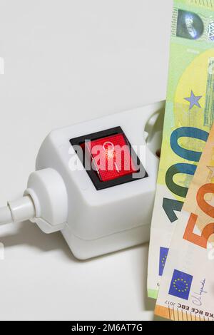 Umschaltbare Steckdosenleiste, Euro-Banknoten, symbolische Kosten für Bildenergie, Stromkosten, Energieeinsparung Stockfoto