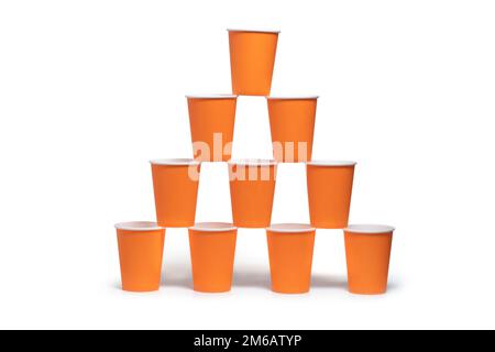 Pyramide orangefarbener Einwegpapierbecher auf weißem Hintergrund isoliert. Stockfoto