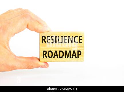 Roadmap-Symbol für Resilienz. Konzeptbegriff „Resilience“-Roadmap auf Holzblöcken getippt. Wunderschöner weißer Tischhintergrund. Geschäftsmannshand. Geschäftlich Stockfoto