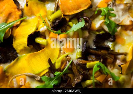 Pizza mit Rucola, Kürbis, Pilzen und Mozzarella. Stockfoto
