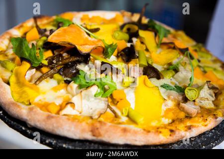 Pizza mit Rucola, Kürbis, Pilzen und Mozzarella. Stockfoto