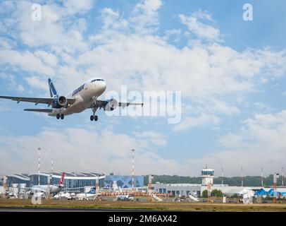 Bukarest, Rumänien - August 2022: TAROM Airbus A318 Flugzeug fliegt gegen den Himmel bei Sonnenuntergang. Das Flugzeug startet vom internationalen Flughafen Henri Coanda Stockfoto