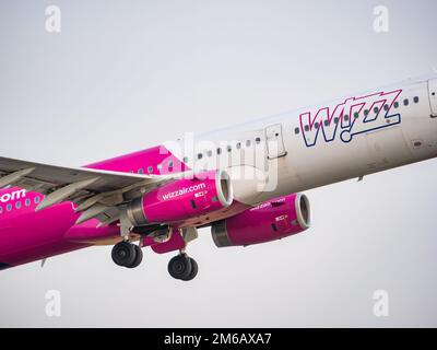 Bukarest, Rumänien - August 2022: Ein Flugzeug des Typs Wizz Air Airbus A321, das vom internationalen Flughafen Henri Coanda aus gegen den blauen Wolkenhimmel fliegt. Stockfoto