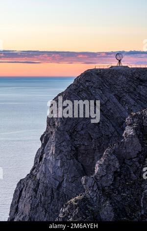 Felsenklippe am Nordkap mit Stahlkugel bei Mitternachtssonne, Nordkapp, Finnmark, Norwegen Stockfoto