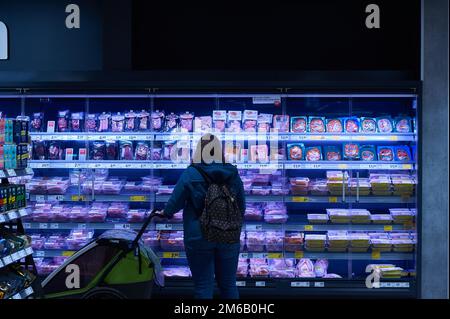 Eine Frau mit Kinderwagen steht vor dem Fleisch- und Wurstkühlregal, Rewe Center Tonndorfer Hauptstraße 71-81, 22045 Hamburg, Deutschland Stockfoto