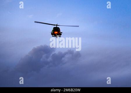 Ein UH-1N-Hubschrauber aus dem 37. Helicopter Swquadron bietet Feuerunterstützung während eines simulierten Konvoi-Angriffs in Camp Guernsey, Wy. Am 21. April 2022. Camp Guernsey war Gastgeber des Energieministeriums während des Konvoi-Trainings. Stockfoto