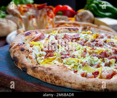 Pizza mit Mais, Speck, Paprika, Zwiebeln, Erbsen Stockfoto