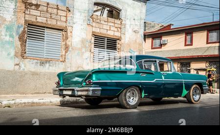 Grüner amerikanischer Oldtimer auf der Straße in der Landschaft von Kuba Santa Clara Stockfoto