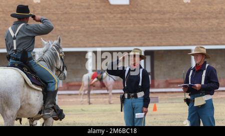 Sergeant Vincent Aquino, ein Spezialfahrzeugmechaniker bei der 4. Infanteriedivision, Fort Carson Mounted Color Guard, und sein Pferd, Sergeant Major Tank, salutieren Richter des regionalen Kavalleriewettbewerbs, 22. April 2022, im Fort Concho National Historic Landmark, San Angelo, Texas. Obwohl es sich um Aquinos ersten Wettbewerb handelte, verfügte der 18-jährige Tank über genügend Wettbewerbskenntnisse und -Erfahrungen für beide. Stockfoto