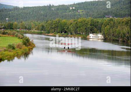 Ein kleines Wasserflugzeug startet vom 10 km langen Chena River, der in den Tanana River in der Nähe von Fairbanks, Alaska, fließt. Stockfoto