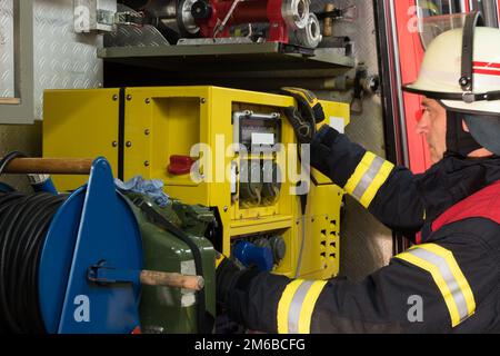 Feuerwehrmann in Aktion am Stromerzeuger Stockfoto